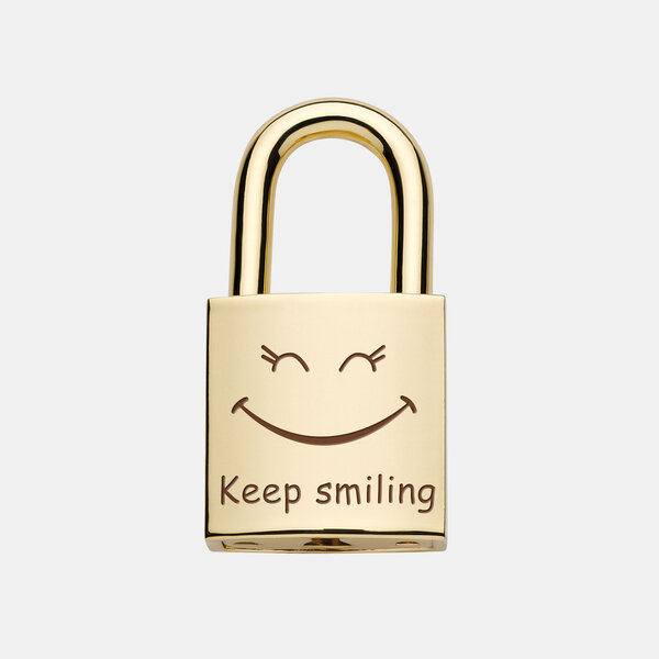 Das goldene Liebesschloss zeigt die Gravur ‚Keep smiling‘ mit einem lächelnden Smiley als positives Symbol.